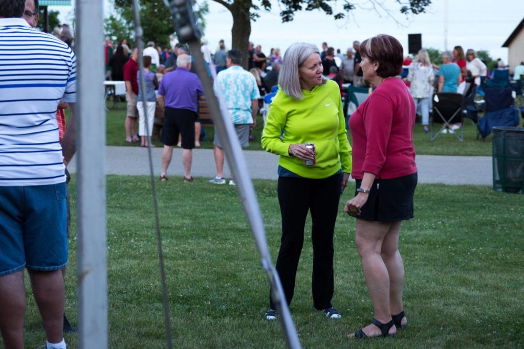   Sisters Kristin Gale and Karen Landry talk with each other next to the Danish Bakery tent during t